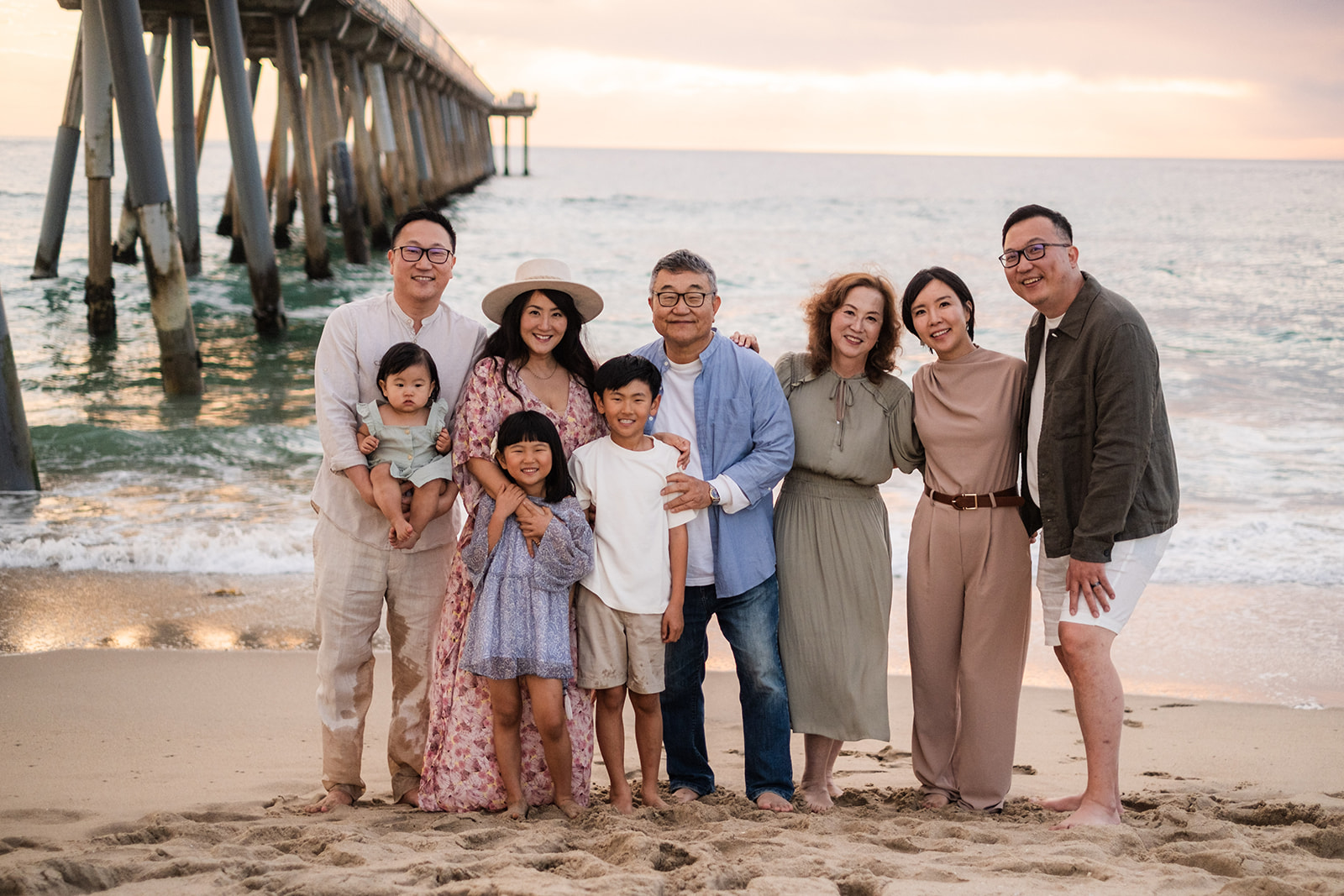 Extended family portrait on the beach beside the pier