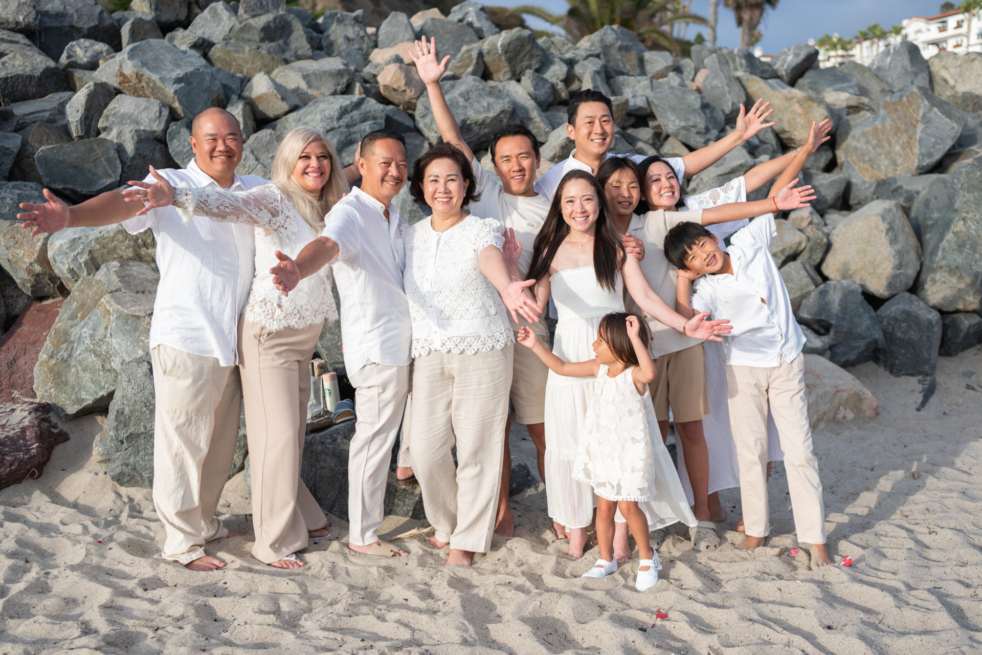 Extended family cheering with arms outstretched by the rocks