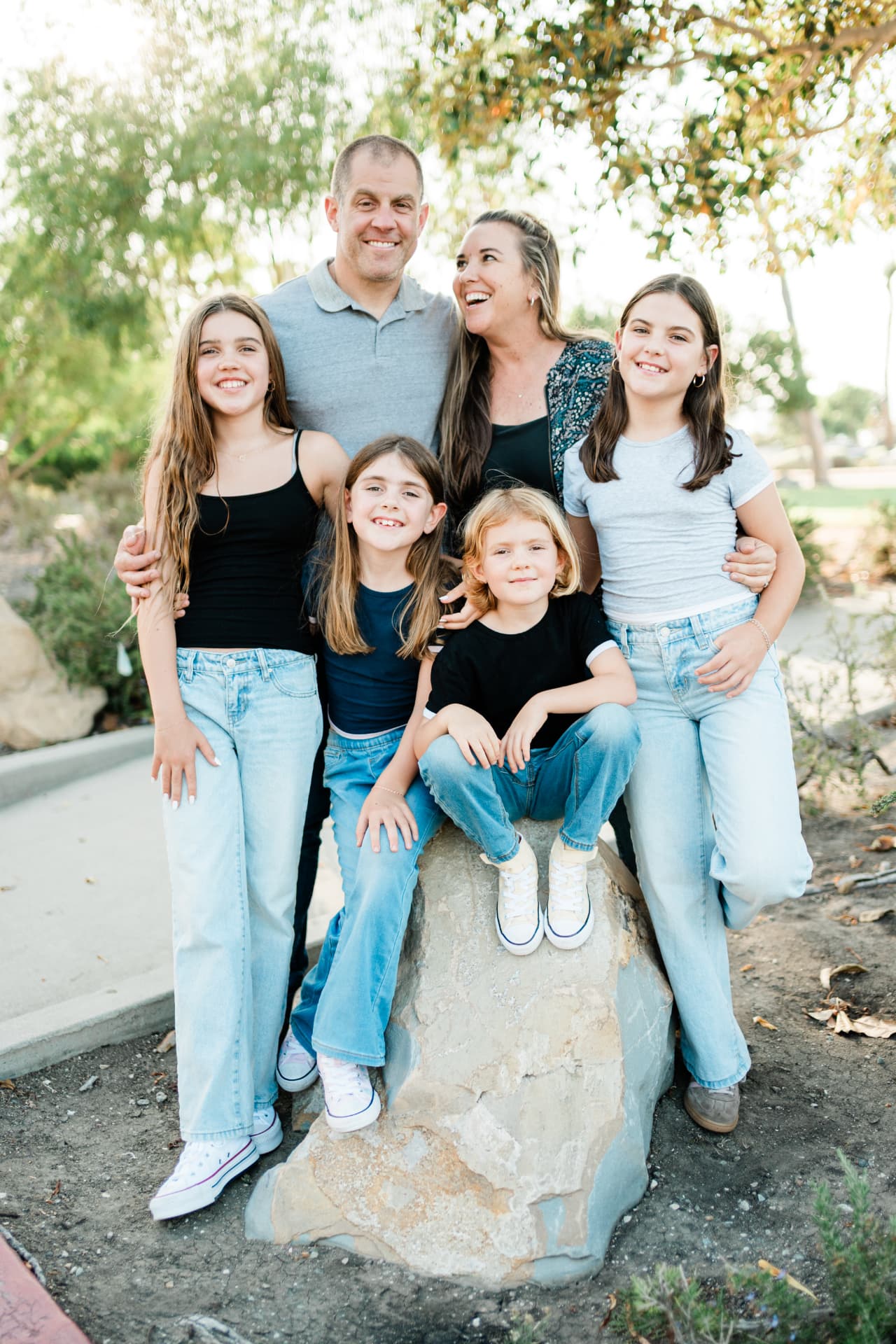 Family gathered around a rock under the trees