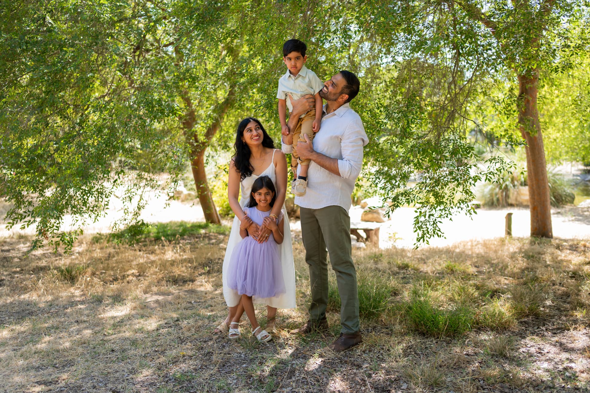 Family of four playing under the trees