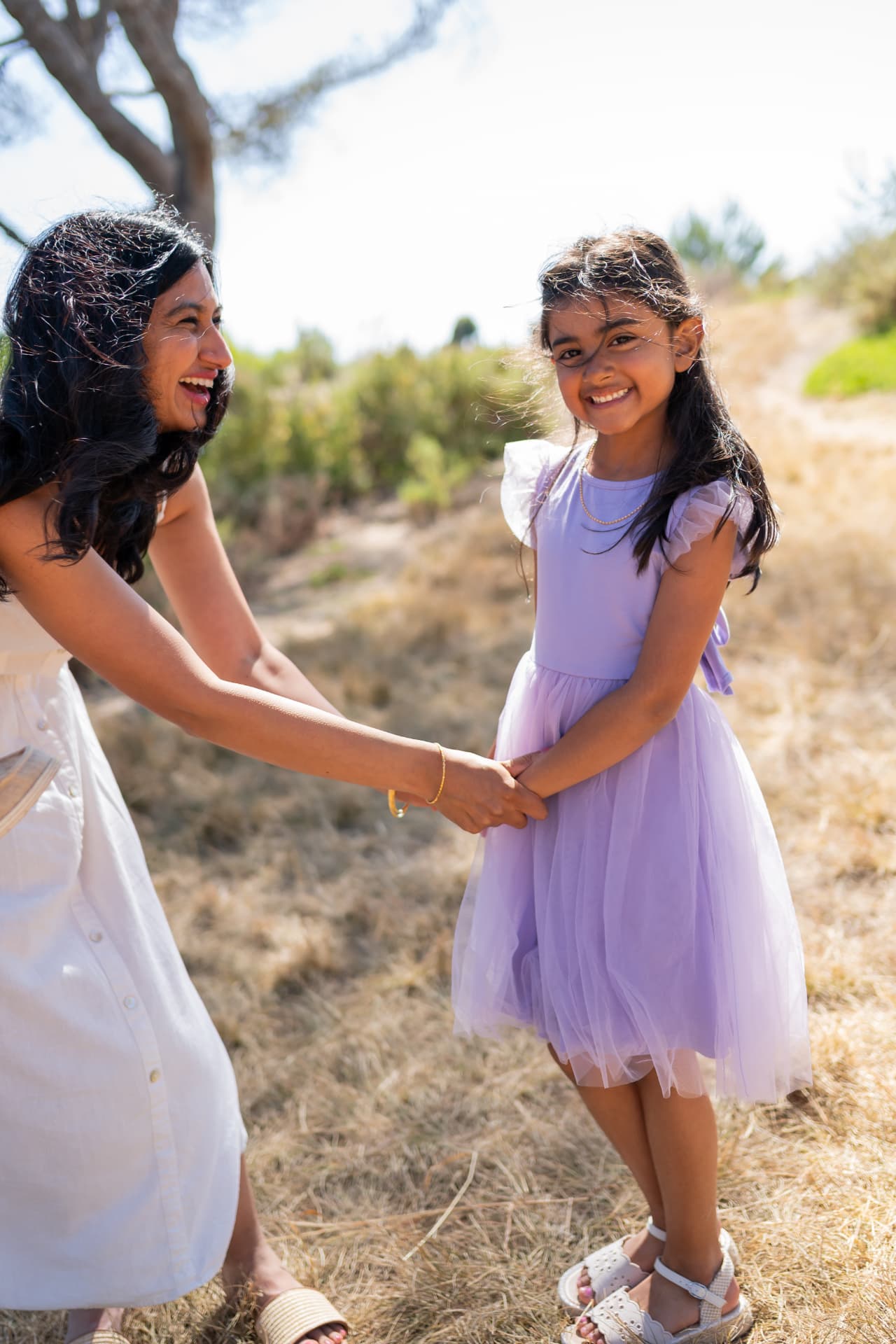 Mom and daughter holding hands in a golden field