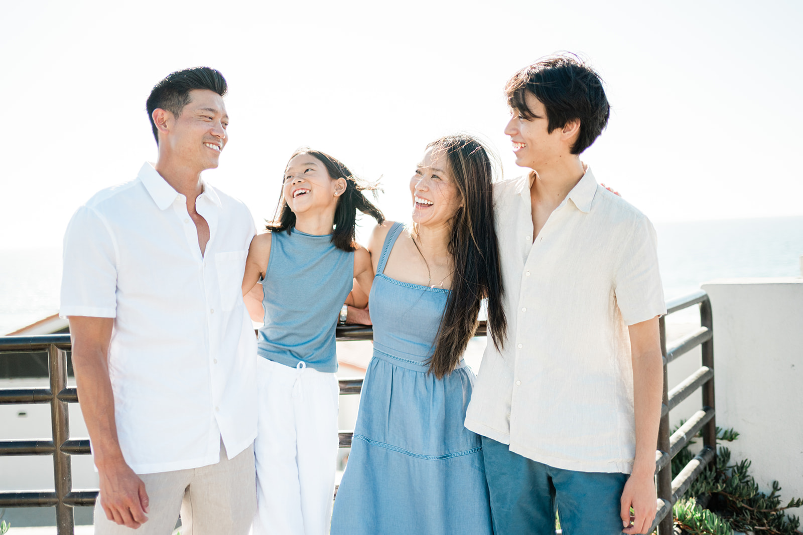 Family laughing together on an oceanfront deck