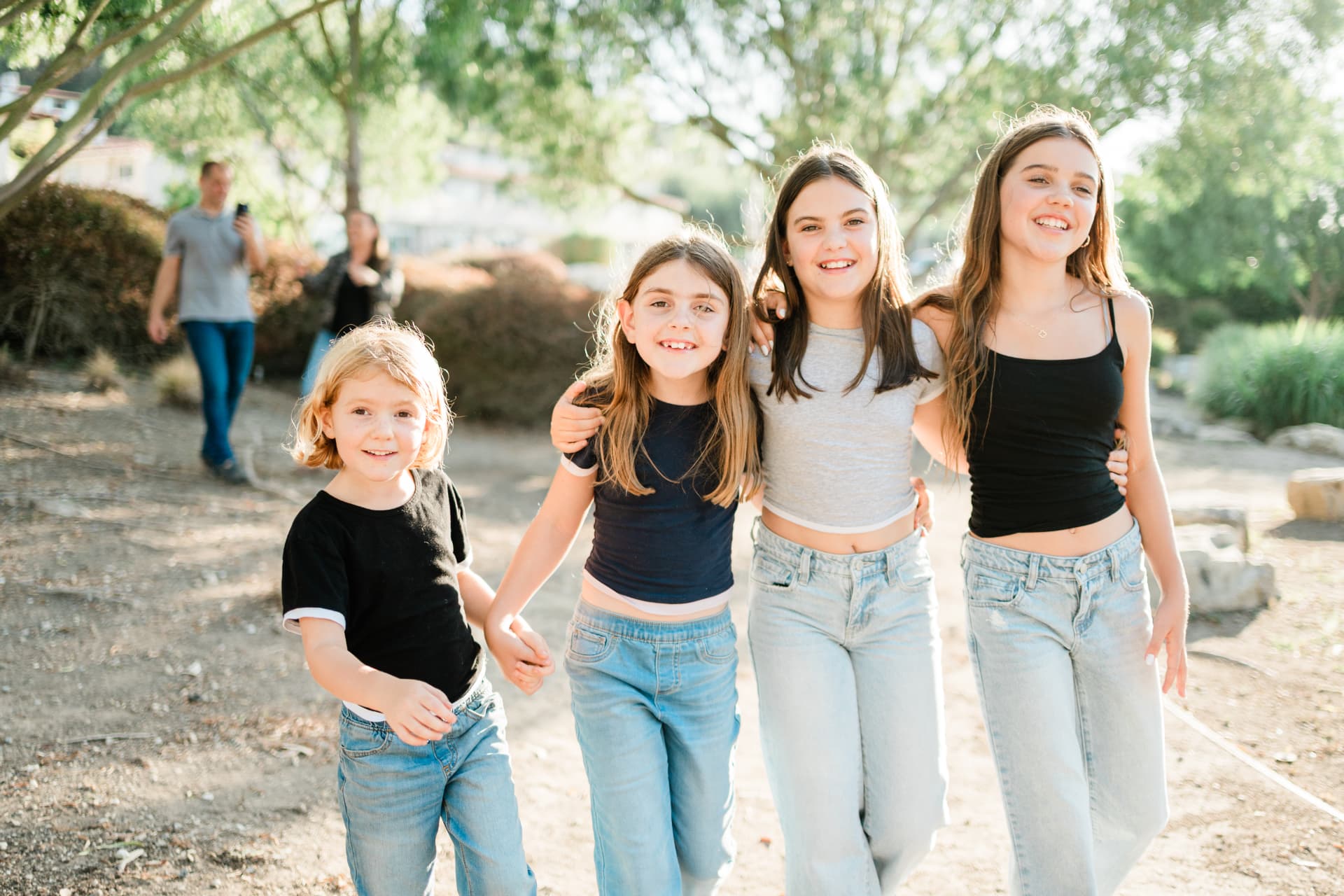 Four sisters walking arm in arm in the afternoon sun