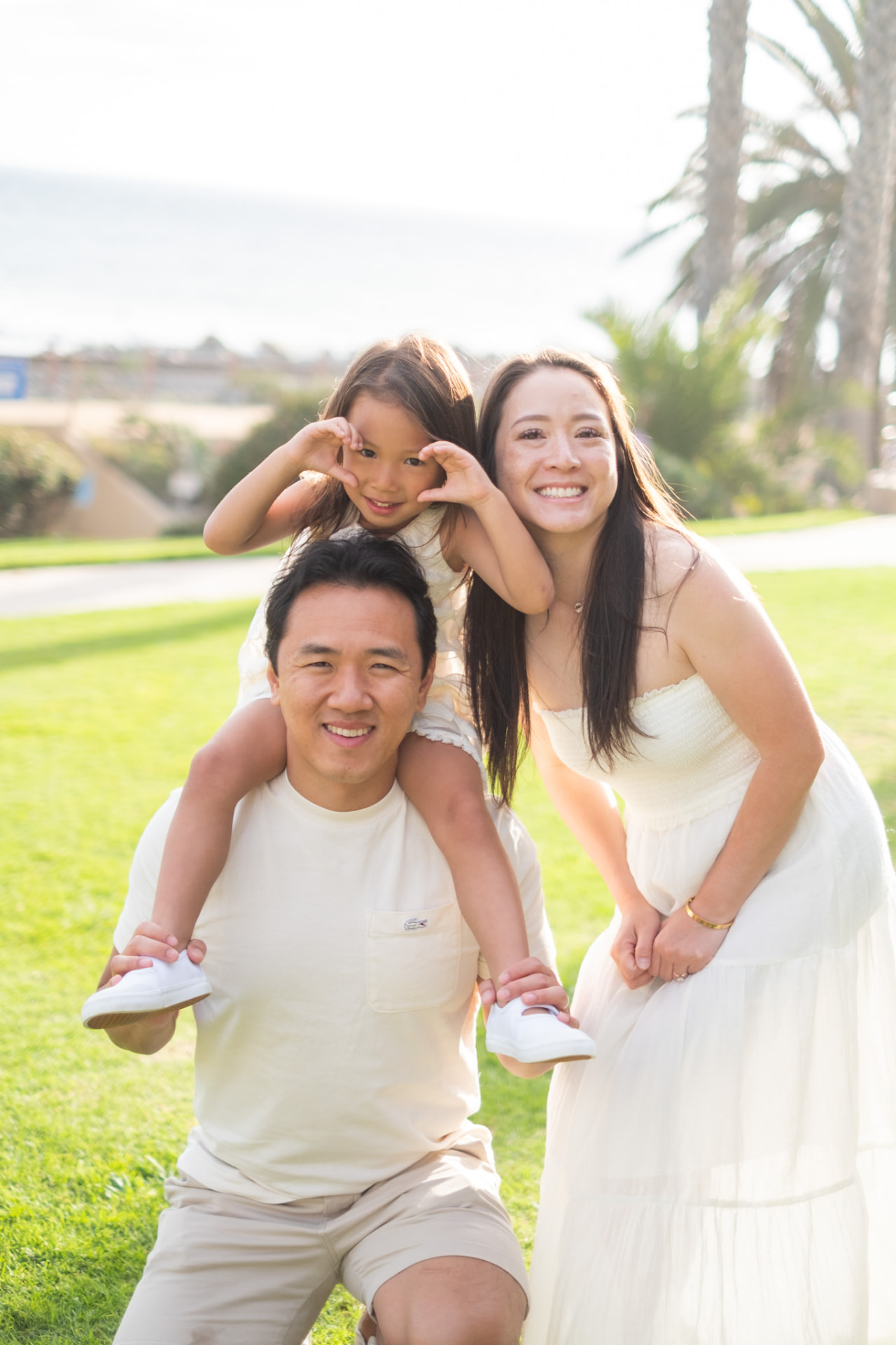 Little girl on her dad's shoulders beside her mom