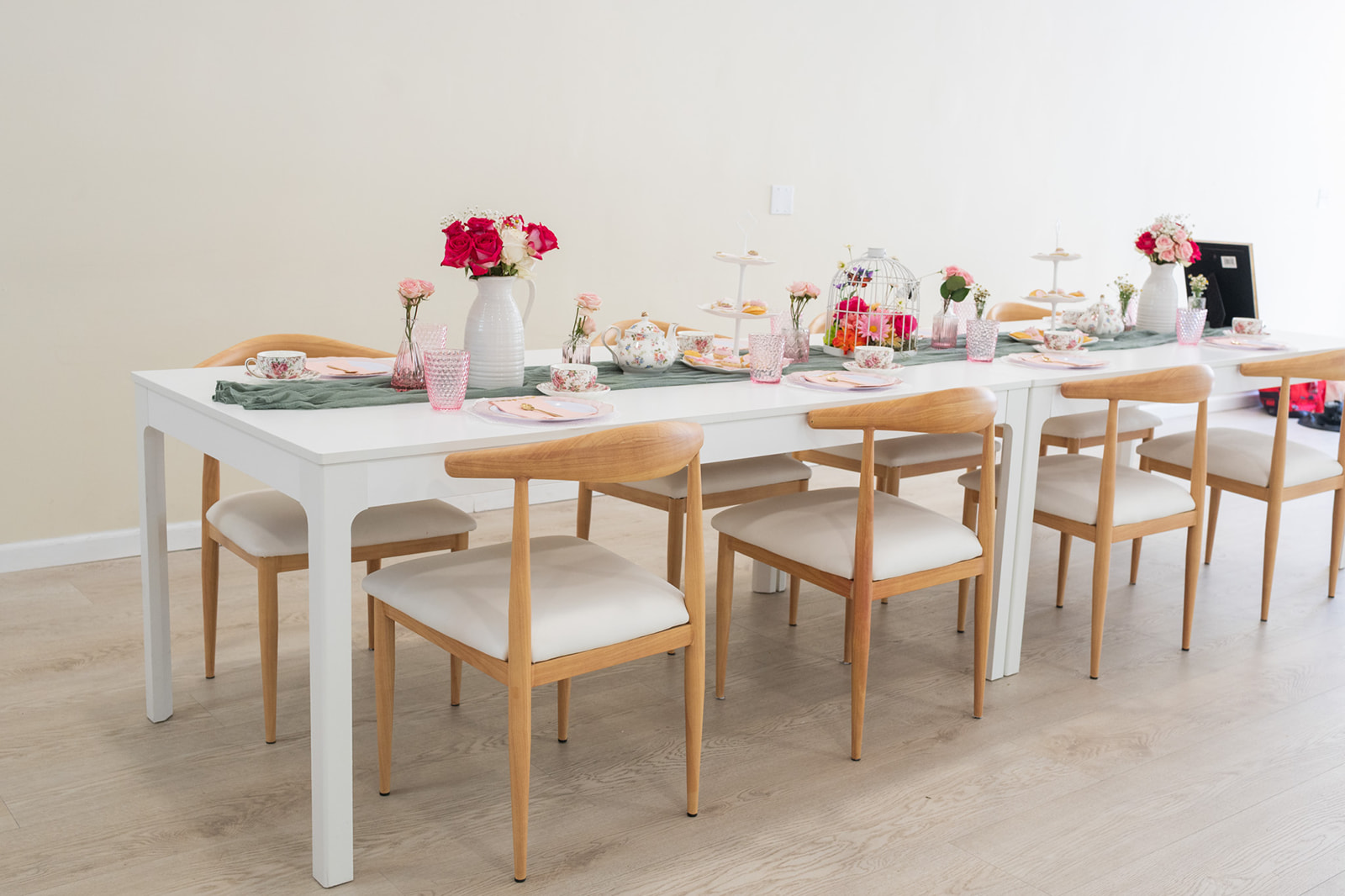Elegant tea-party inspired tablescape at The Elle Venue in Rolling Hills Estates, California, with pink glassware, floral china, and lush red and pink blooms.