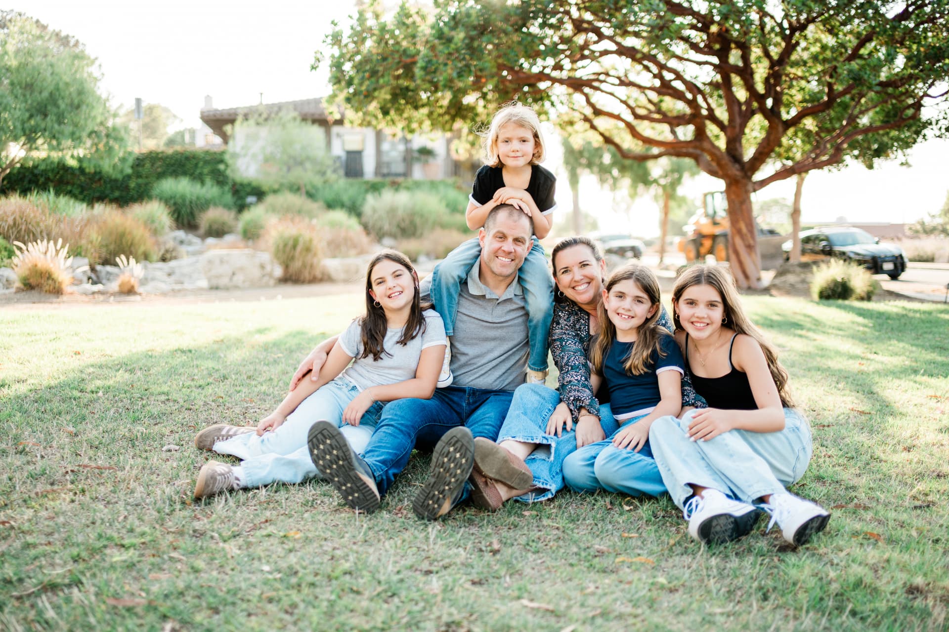 Family sitting together on the grass at golden hour